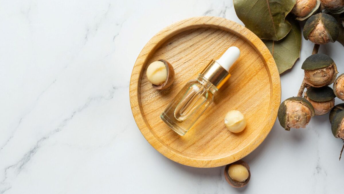 olej tamanu leżący w butelce obok orzechów tamanu