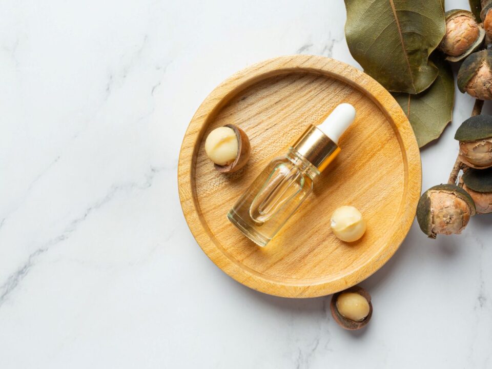 olej tamanu leżący w butelce obok orzechów tamanu